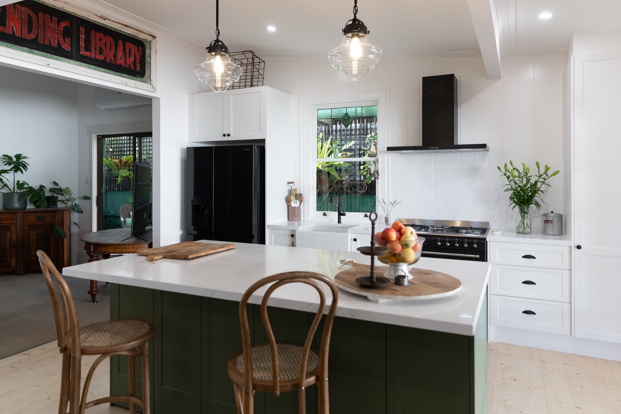 A finished Australian-made kitchen showing custom cabinetry, stone benchtop and timber accents
