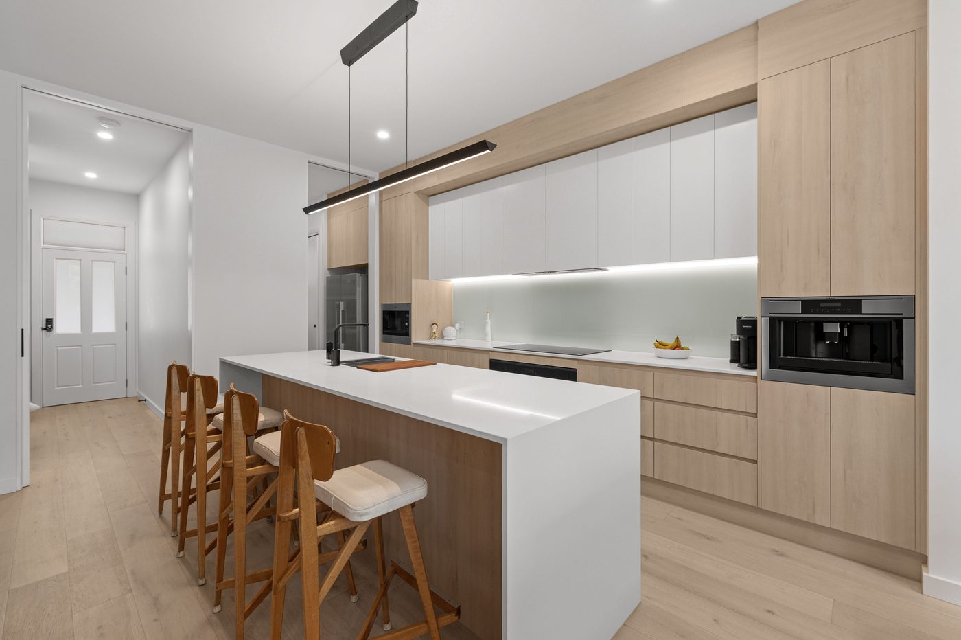 White stone waterfall bench top in a timber kitchen
